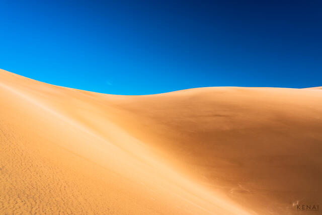 Sand dunes in Great Sand Dune National Park Colorado contrast with a brilliant blue sky in winter.