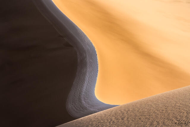 Snow and orange sand meet in an abstract image of the Great Sand Dunes National Park, Colorado.