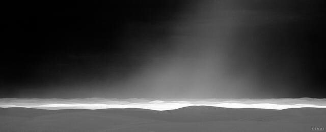 Black and white photo of sunlight in a storm at white sands national park new mexico.