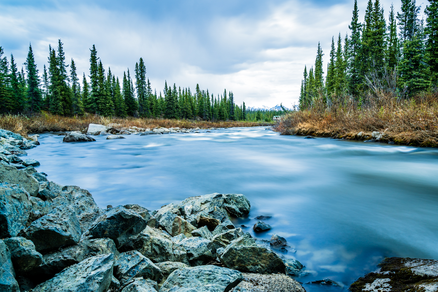 A cabin stands by a remote river along the Denali Highway, deep in the heart of Alaska.