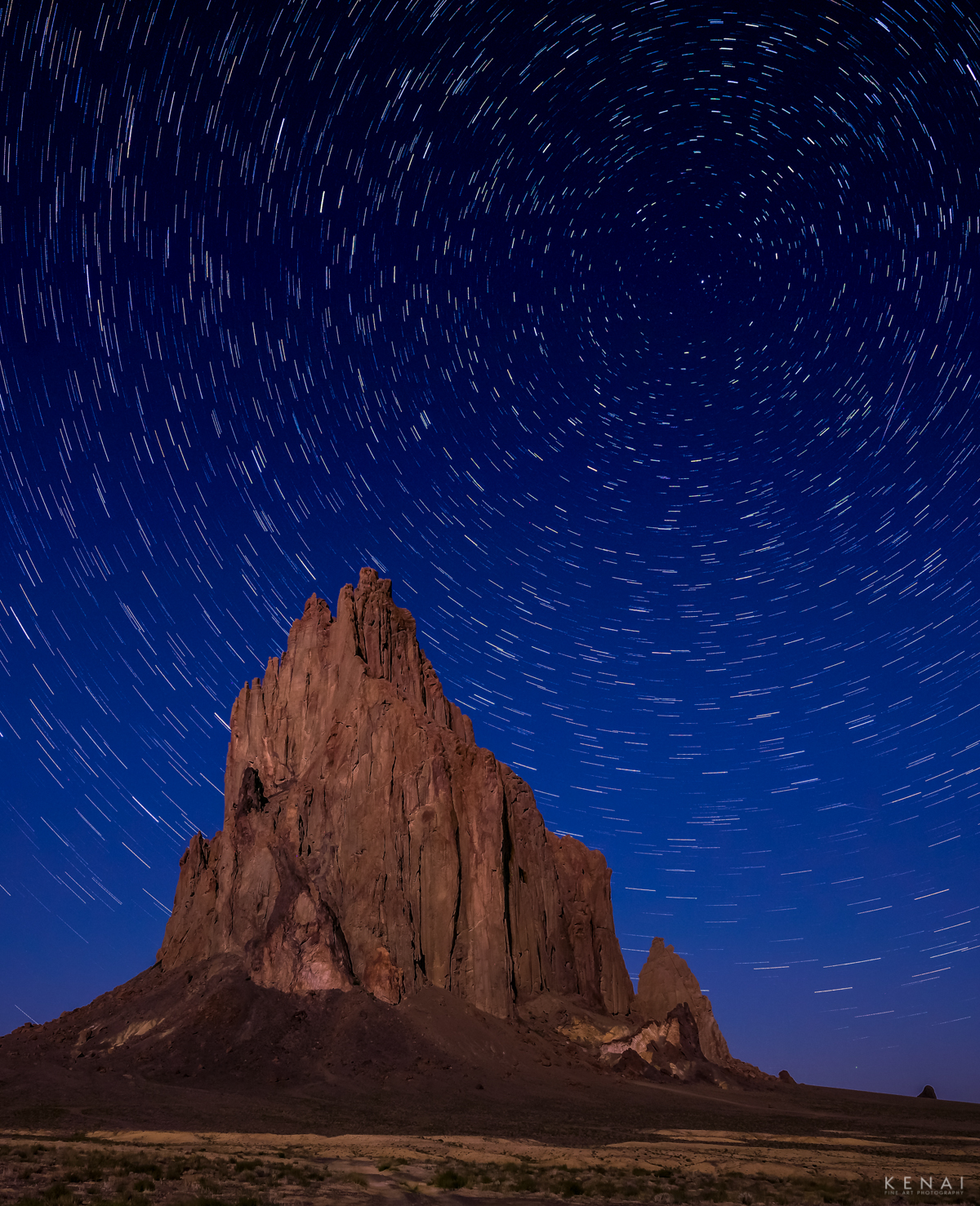 Long exposure, night image of Shiprock, New Mexico with star trails and moonlight in the desert.